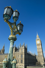 Fototapeta na wymiar Big Ben shines in bright morning sun behind a decorative lamppost at Westminster Palace London