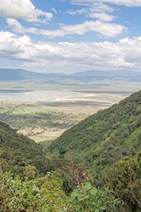Naklejka premium View on huge Ngorongoro caldera (extinct volcano crater) with large lake from cleft against blue sky background. Great Rift Valley, Tanzania, East Africa. 