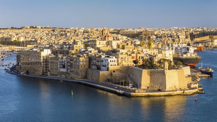 Malta - Aerial view of the ancient walls of Senglea and Gardjola Gardens shot from Valletta on a sunny day with blue sky