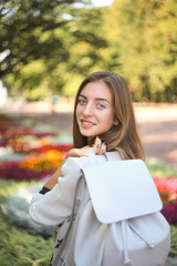 Fototapeta premium Young student girl with white leather bag in park