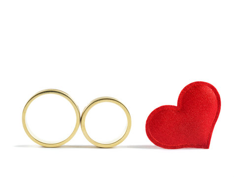 Wedding rings and read heart on white background. Concept for love