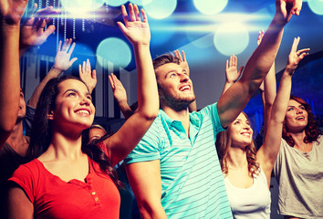 smiling friends at concert in club