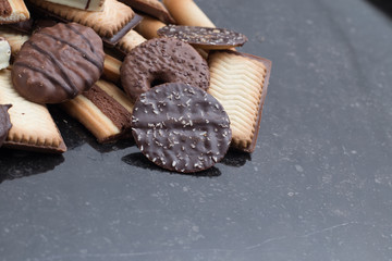Cookies assorted on black background. Delicious morning snacks for breakfast, brunch and lunch. Appetizing, sweet and fast food.