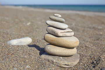 Fototapeta na wymiar Stone pyramid on a pebble beach