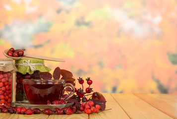 Berries and  cup  tea on  background  autumn leaves.