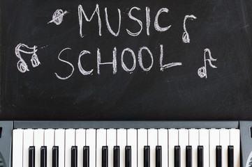 Fototapeta premium Music keyboard on blackboard background for music school children with copy space
