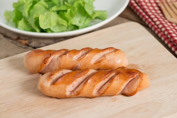 Grilled sausages on wood board.
