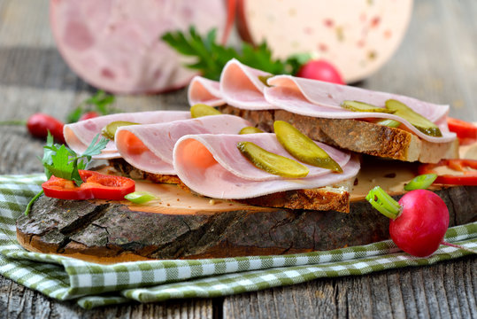 Wurstbrote: Deftiges Landbrot belegt mit Bierschinken rustikal serviert - Slices of Bavarian sausage on farmhouse bread