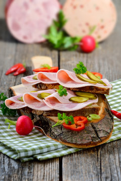 Deftiges Landbrot belegt mit Bierschinken rustikal serviert - Slices of Bavarian sausage on farmhouse bread