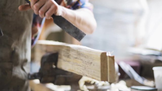 carpenter with chisel working at workshop