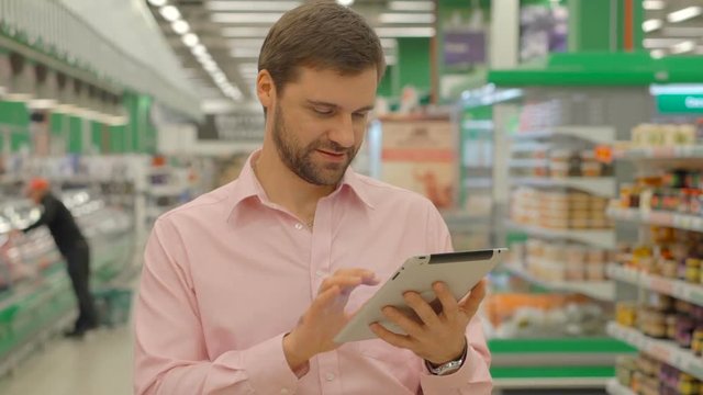 Man holding tablet in hypermarket store