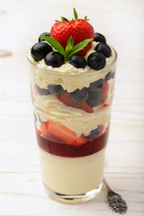 Layered strawberry dessert - panna cotta with berry jelly, blueberries and strawberries.