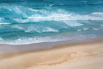 Blue Waves crashing on beach Aerial view