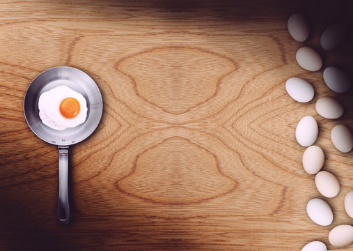 Frigideira com ovo frito sobre mesa de madeira