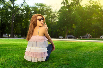 Surprised young woman sitting on the lawn