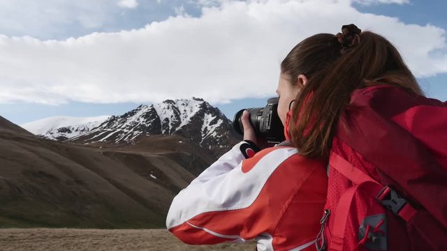 Woman photographs the mountain peaks