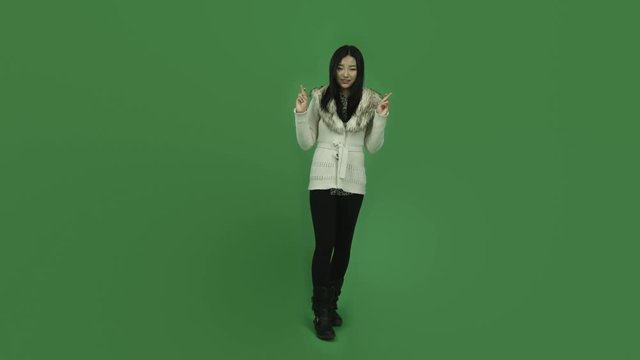 Asian girl young adult isolated greenscreen green background with fingers crossed
