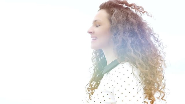 Portrait of  young woman with beautiful curly hair making a hushing gesture on white background, slow motion