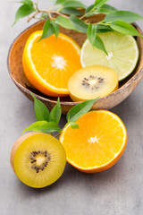 Mixed citrus fruit lemons, orange, kiwi, limes on a gray backgro