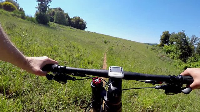 Young man on mountain bike along dirt trail. POV first person view. Video form action cam and gimbal, steady cam