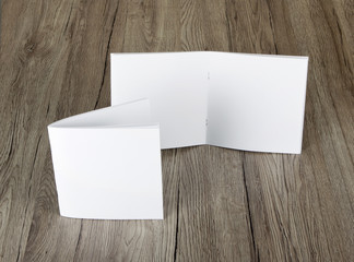 Blank catalog, brochure, magazines, book on wooden background