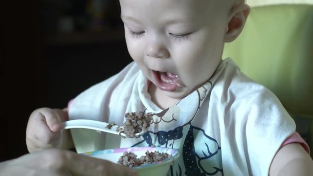 Portrait of baby girl eating porridge
