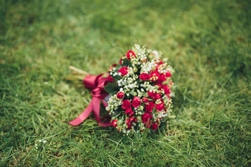 Bouquet of beautiful flowers and greenery is on the green grass