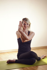 Fototapeta na wymiar Frau die Yoga macht im sitzen