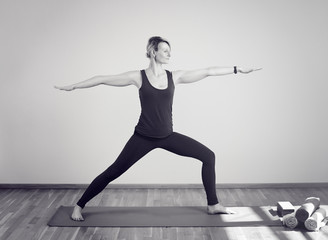 Frau die Yoga macht im stehen auf Yogamatte