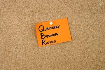 QBR as QUARTERLY BUSINESS REVIEW written on orange paper note