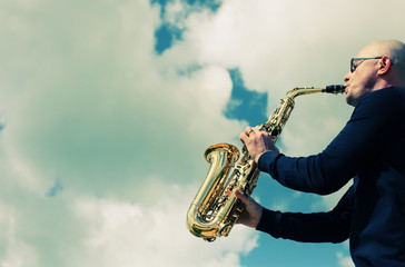 Fototapeta na wymiar Saxophonist playing on saxophone outdoor