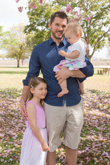 Man with two daughters in park with flowers