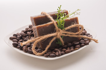 Traditional home made natural coffee soap with a pile of coffee beans on the background suggesting healthy organic non toxic wash products