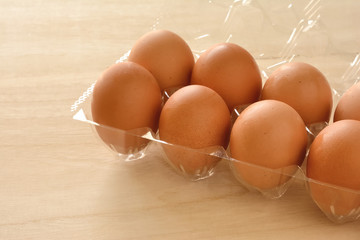 パックに入った赤玉の卵　木目背景

