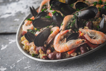 Paella in the metal plate on the metal background horizontal