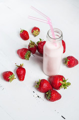 Strawberry yogurt with fresh strawberries on a white wooden background