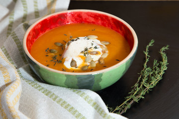 Pumpkin cream soup with chicken fillet, thyme and pumpkin seeds.