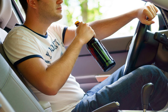 Man drinking beer while driving the car.