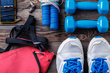 Shoes and sports equipment on wooden floor, top view