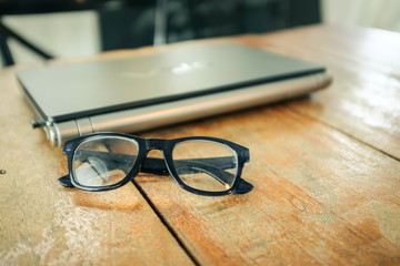 Glasses with laptop Workspace on wood table