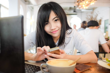 Young asian woman drinking coffee at cafe