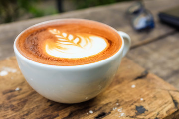 Wake up concept a cup of latte art coffee on the wooden table