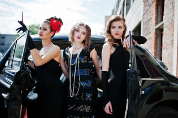 Three young girl in retro style dress near old classic vintage c