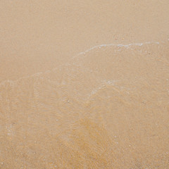 closeup of sand pattern texture of a beach with sea water