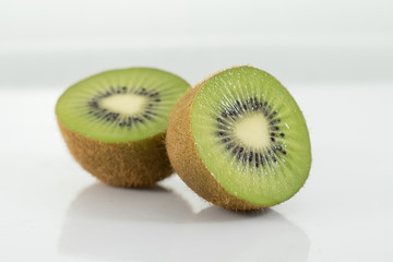 Kiwi fruit halves on white background
