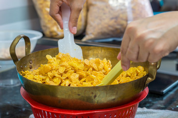 Hands with corn flakes in cooking. They are made by toasting flakes of corn.