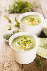 Zucchini soup with peas, decorated with egg