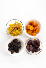 dried fruit, deep plates, on a white background. dates, raisins,