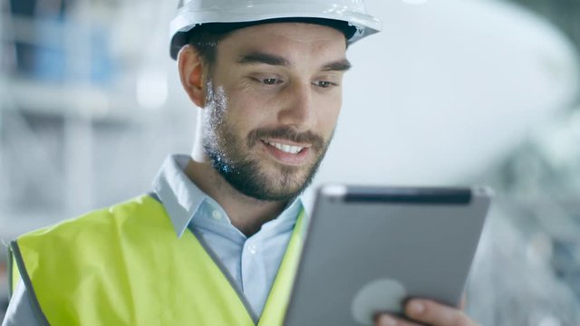 Portrait of Aircraft Maintenance Mechanic in Safety Vest using Tablet Computer. Shot on RED Cinema Camera.