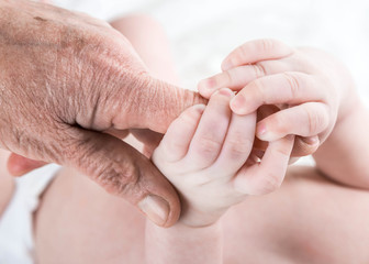.Grandma's hands taking care of the baby , soft skin